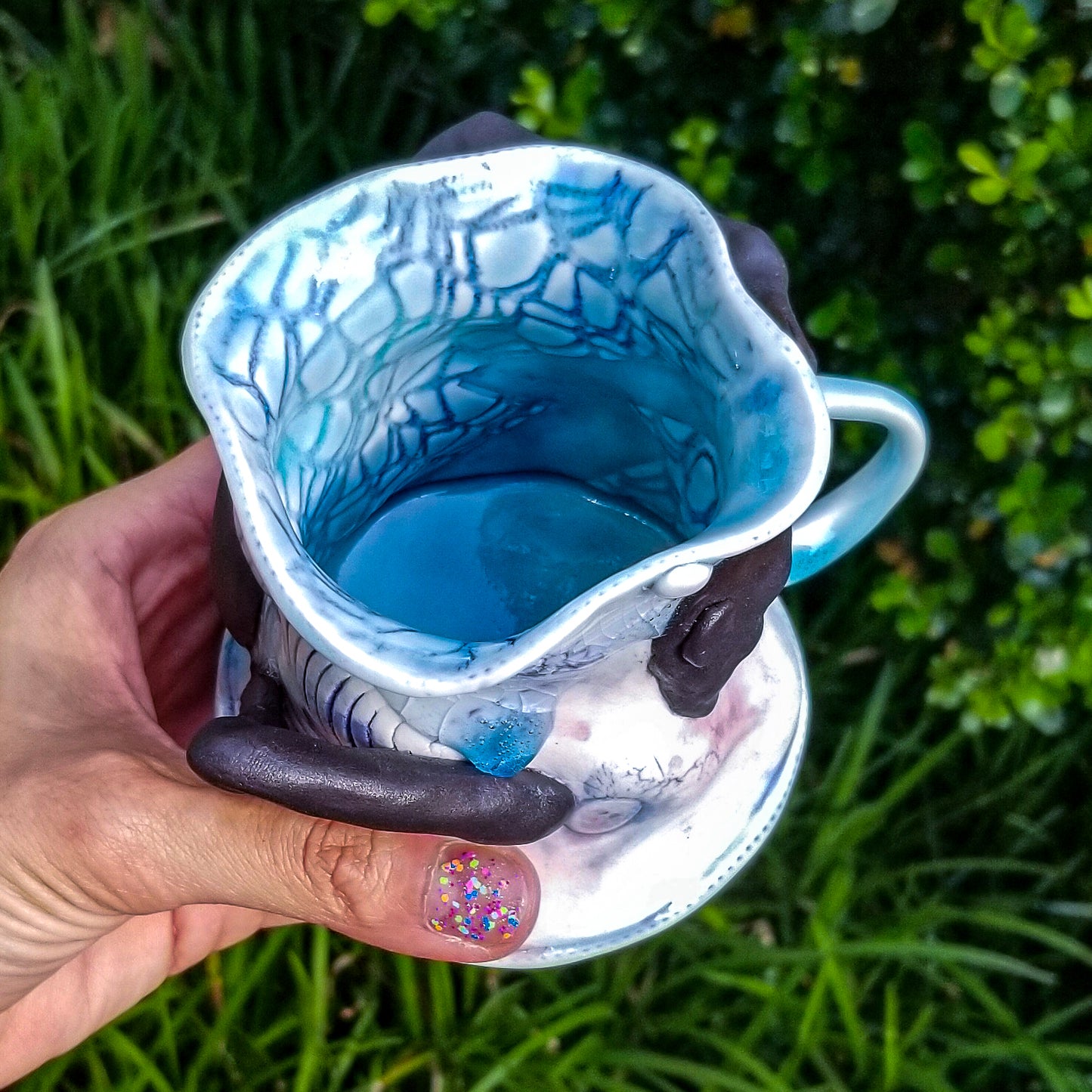 Inside detail of handmade porcelain mug with figurative sculptural elements