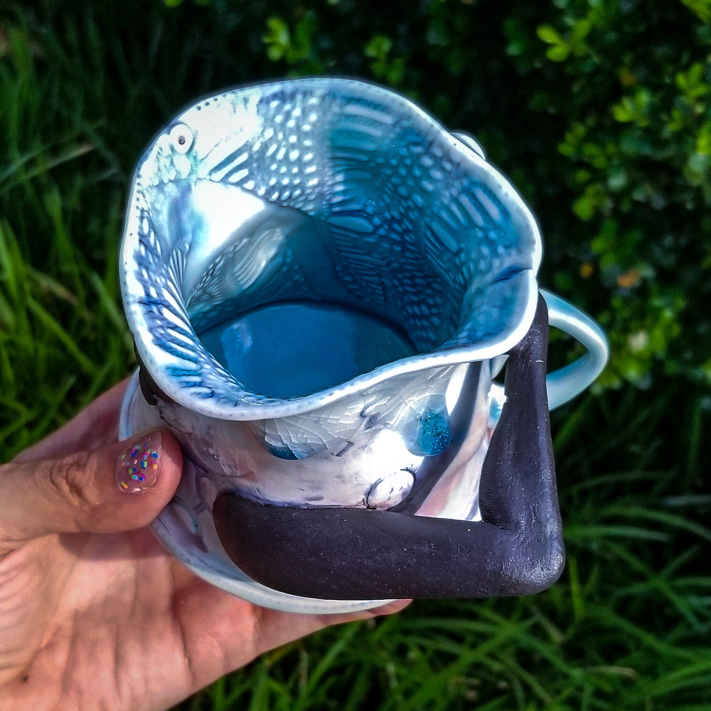 Inside detail of handmade porcelain mug with figurative sculptural elements