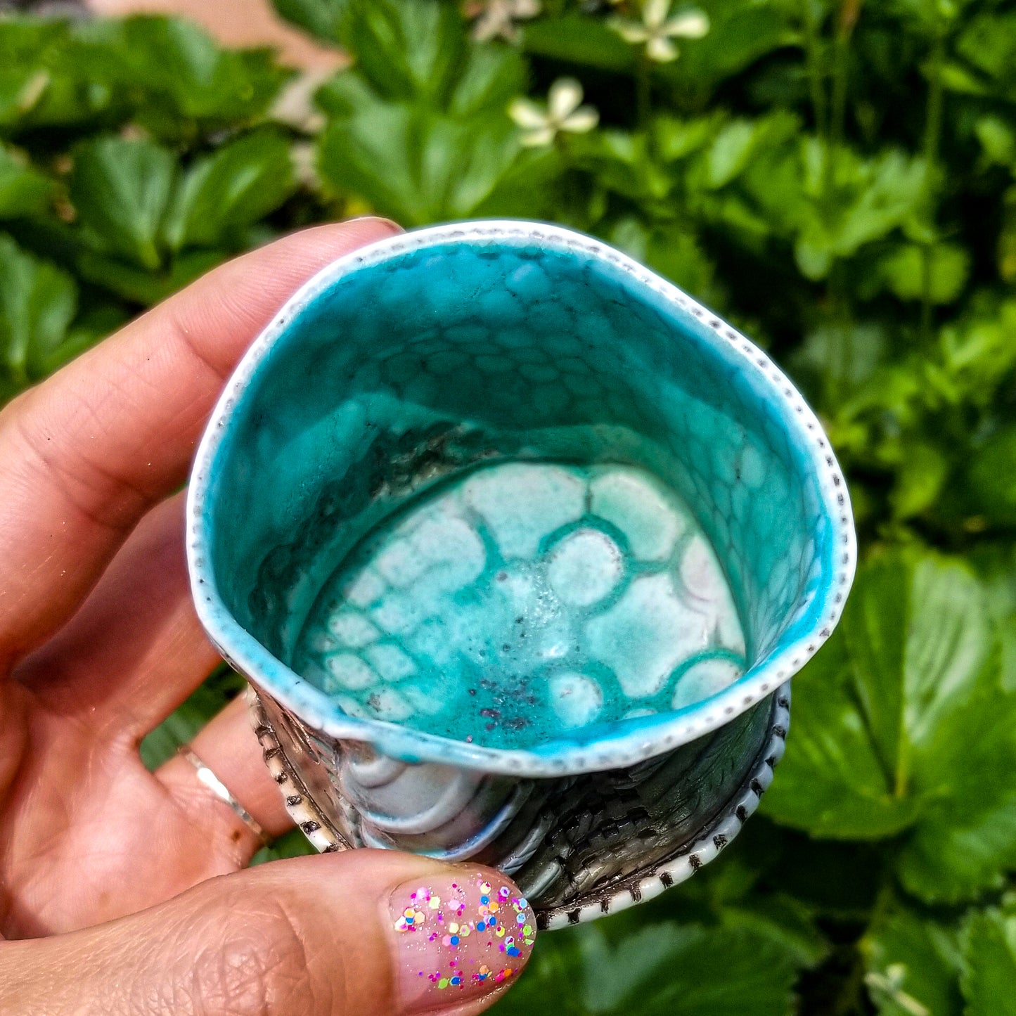 Inside view of handmade stoneware ceramic soda fired cup blue color with pressed textures
