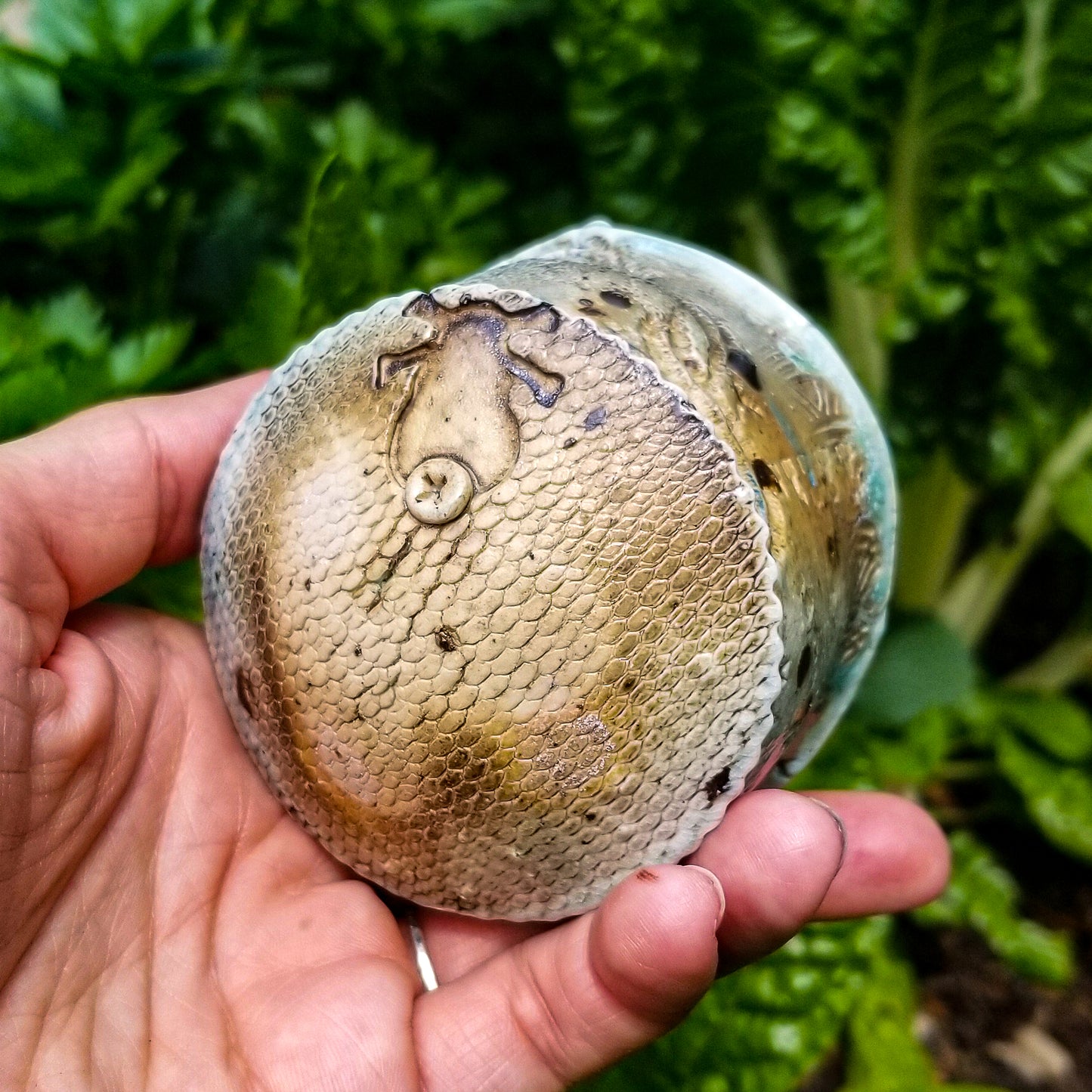 Bottom detail of handmade stoneware ceramic soda fired cup blue color with pressed textures