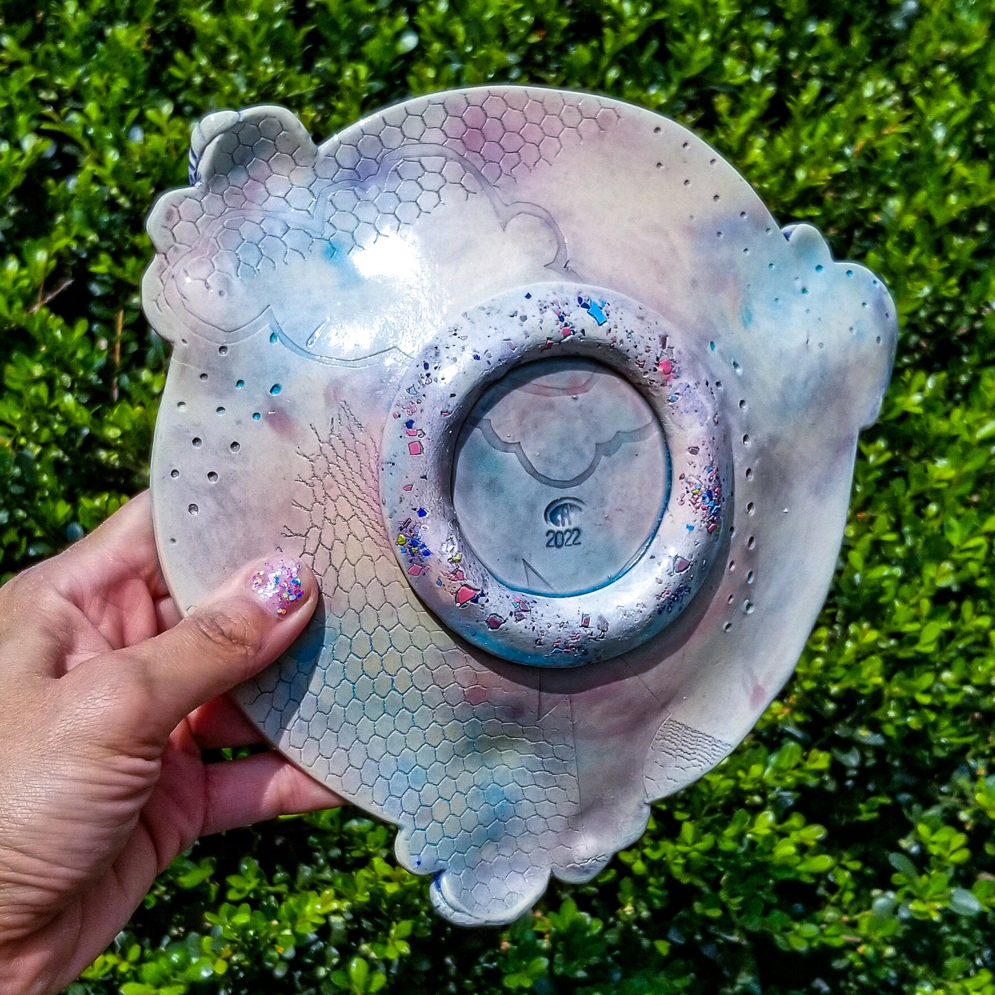 Bottom detail of handmade ceramic soda fired plate multi color with pressed textures