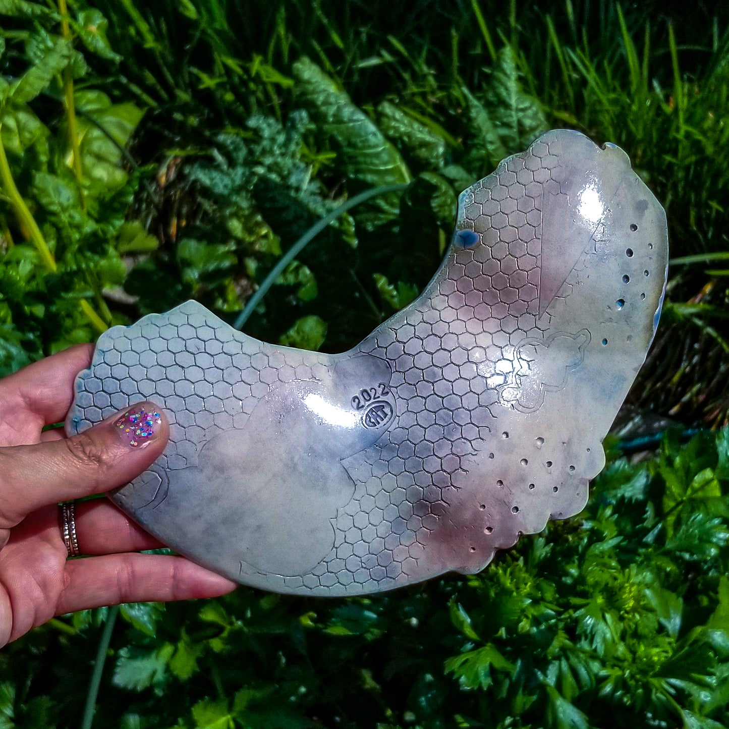 Bottom detail of handmade porcelain ceramic soda fired rainbow shaped tray multi color with pressed textures