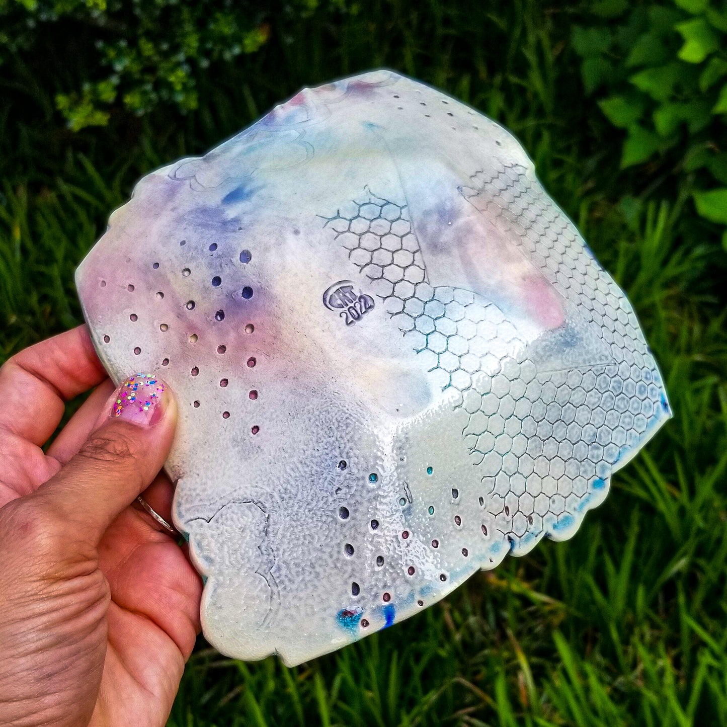 Bottom detail of handmade porcelain ceramic soda fired dish multi color with pressed textures