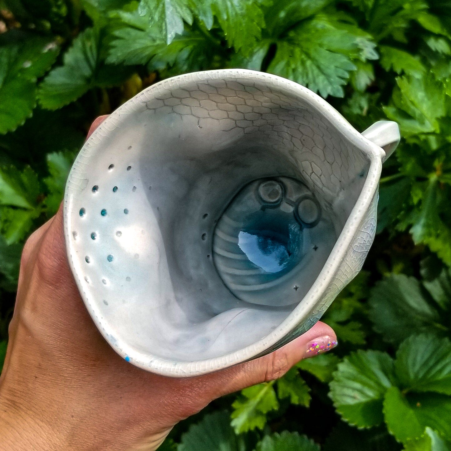 Inside detail of handmade stoneware ceramic soda fired mug blue color with pressed textures
