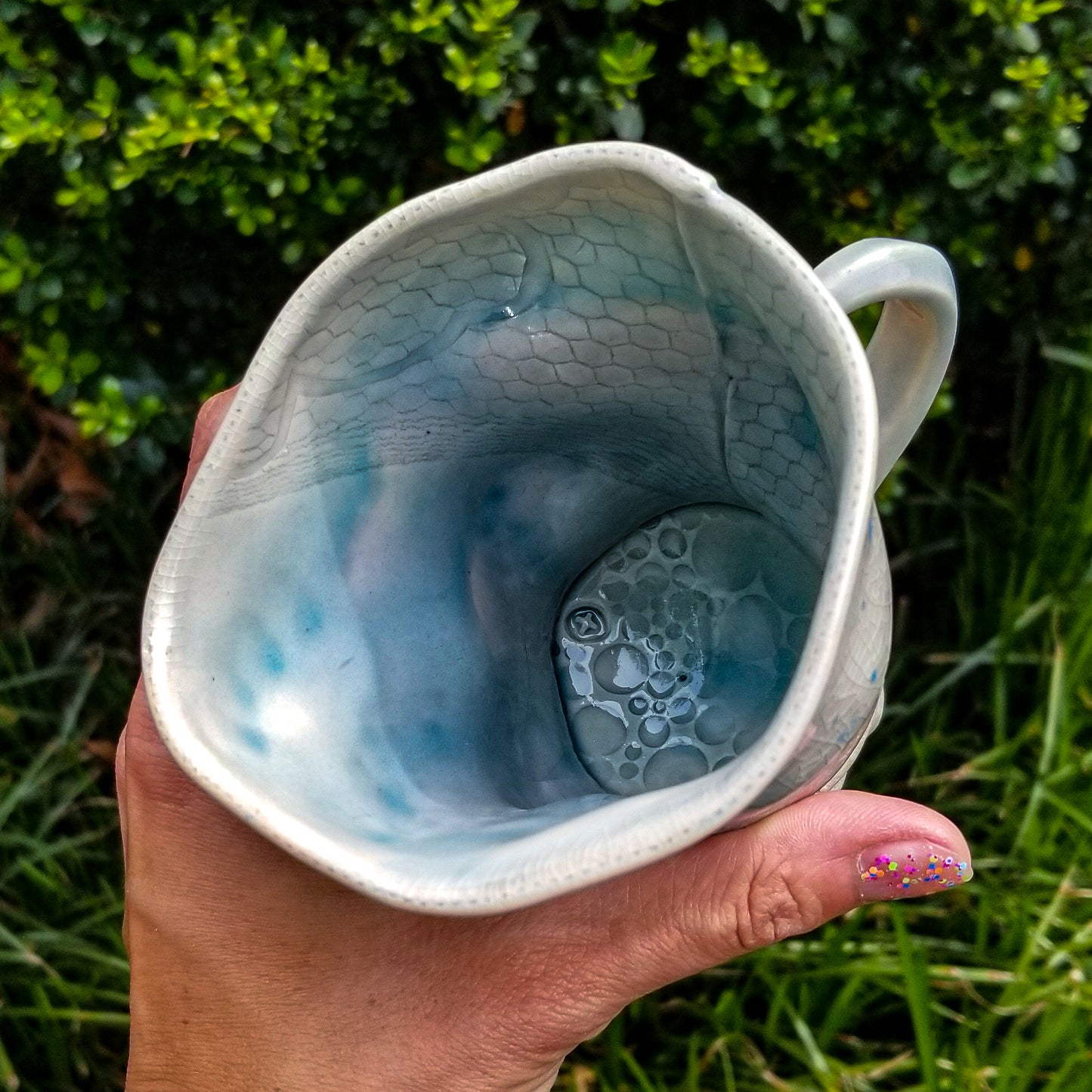 Inside detail of handmade stoneware ceramic soda fired mug blue color with pressed textures