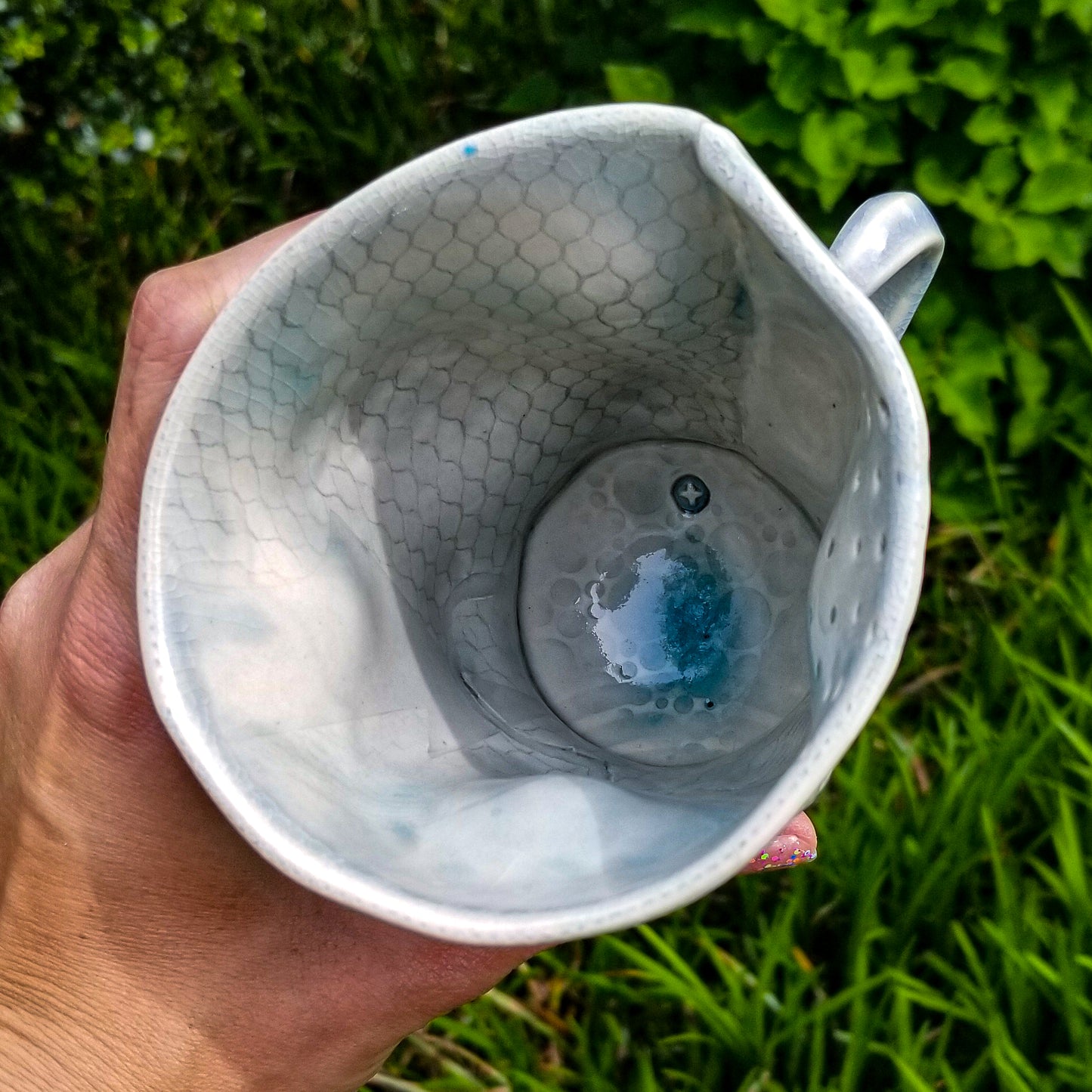 Inside detail of handmade stoneware ceramic soda fired mug blue color with pressed textures