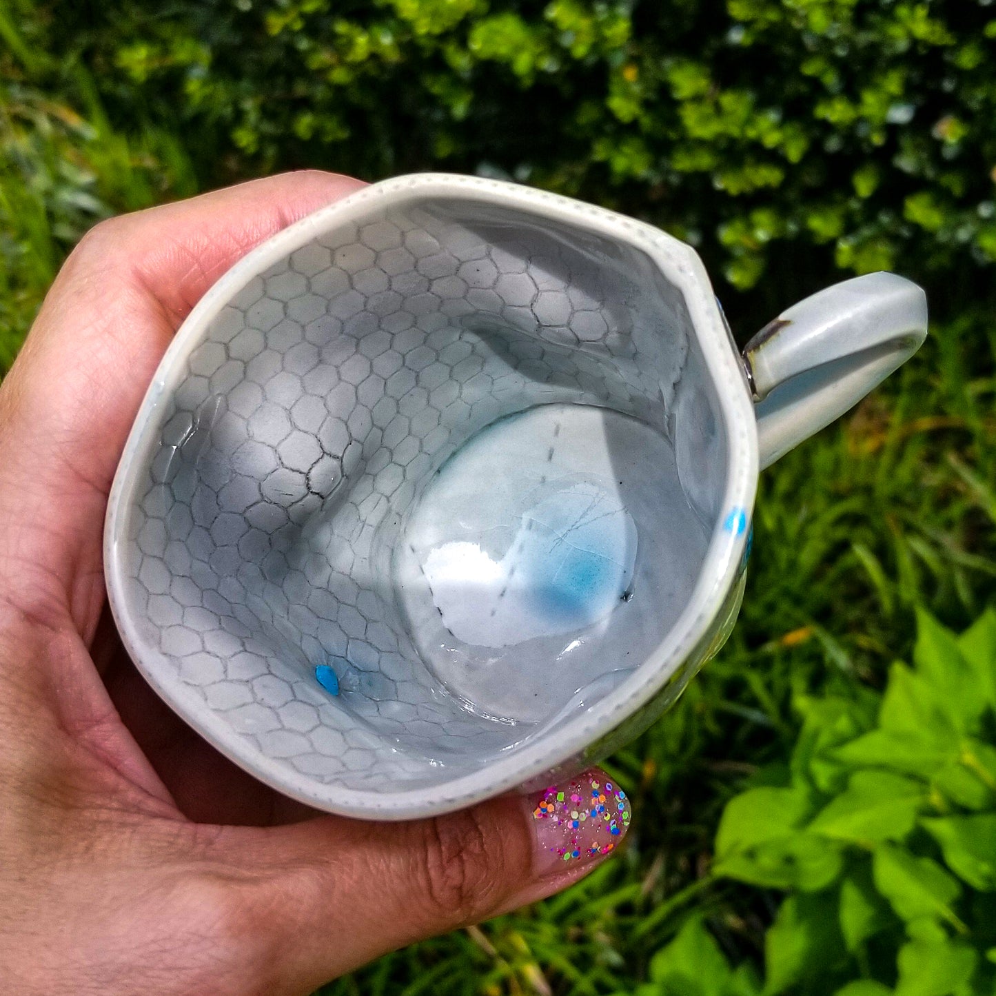 Inside detail of handmade stoneware ceramic soda fired mug blue color with pressed textures