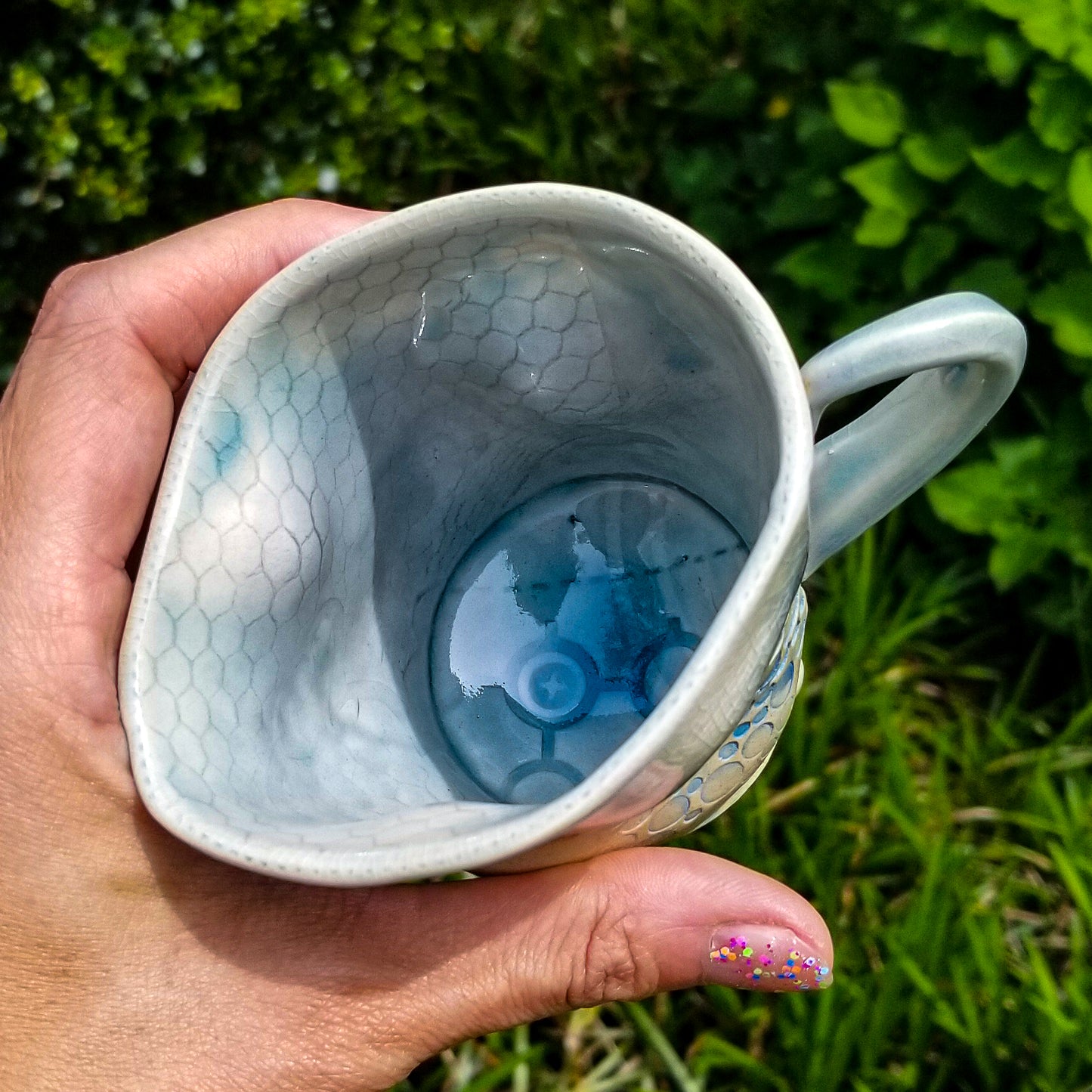 Inside detail of handmade stoneware ceramic soda fired mug blue color with pressed textures