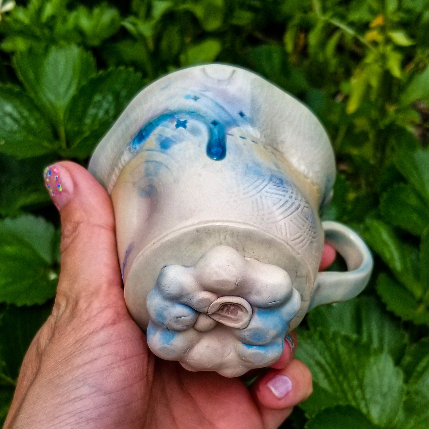 Bottom detail of handmade stoneware ceramic mug blue color with pressed textures