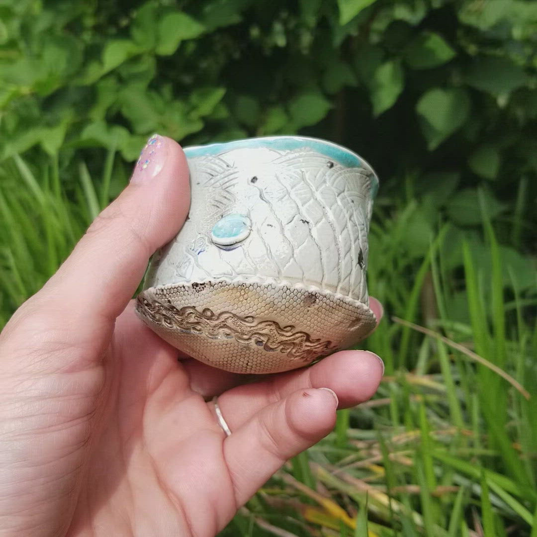 Video of handmade stoneware ceramic soda fired cup blue color with pressed textures
