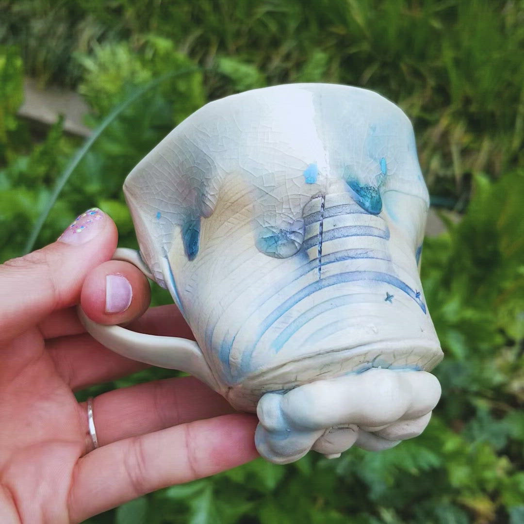 Video of handmade stoneware ceramic mug blue color with pressed textures