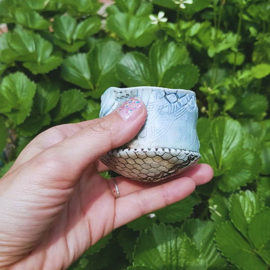 Video of handmade stoneware ceramic soda fired cup blue color with pressed textures