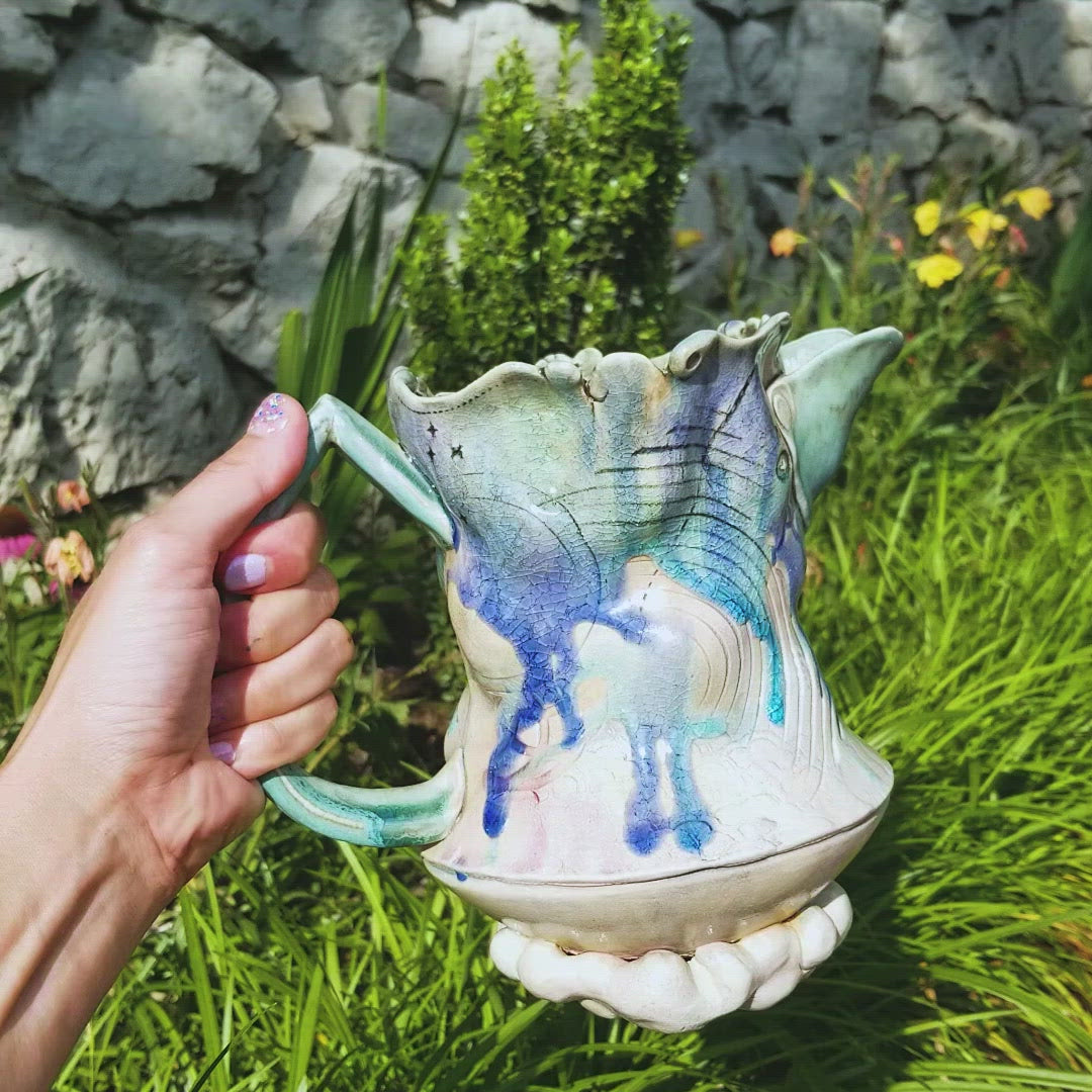 Video of hhandmade stoneware ceramic soda fired pitcher blue color with pressed textures