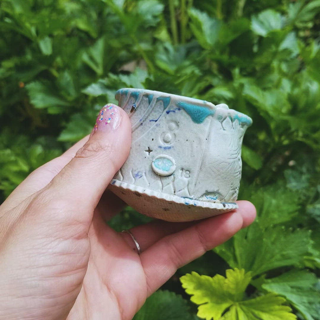 Video of handmade stoneware ceramic soda fired cup blue color with pressed textures