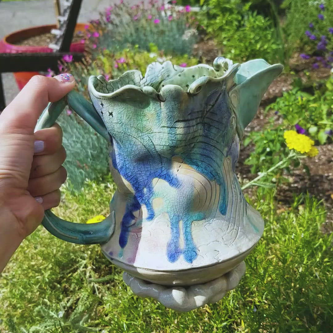 Video of pouring handmade stoneware ceramic soda fired pitcher blue color with pressed textures