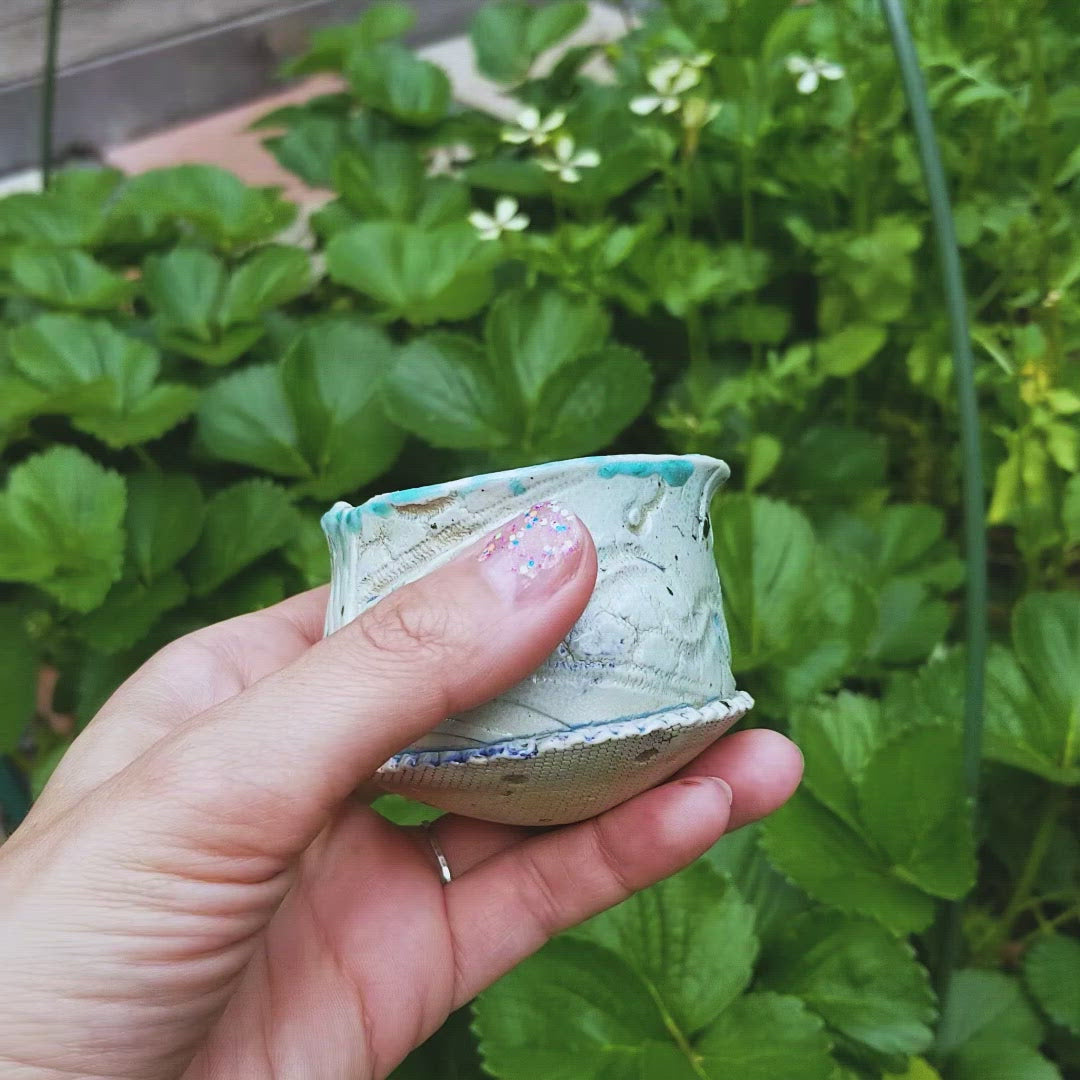 Video of handmade stoneware ceramic soda fired cup blue color with pressed textures