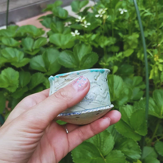 Video of handmade stoneware ceramic soda fired cup blue color with pressed textures