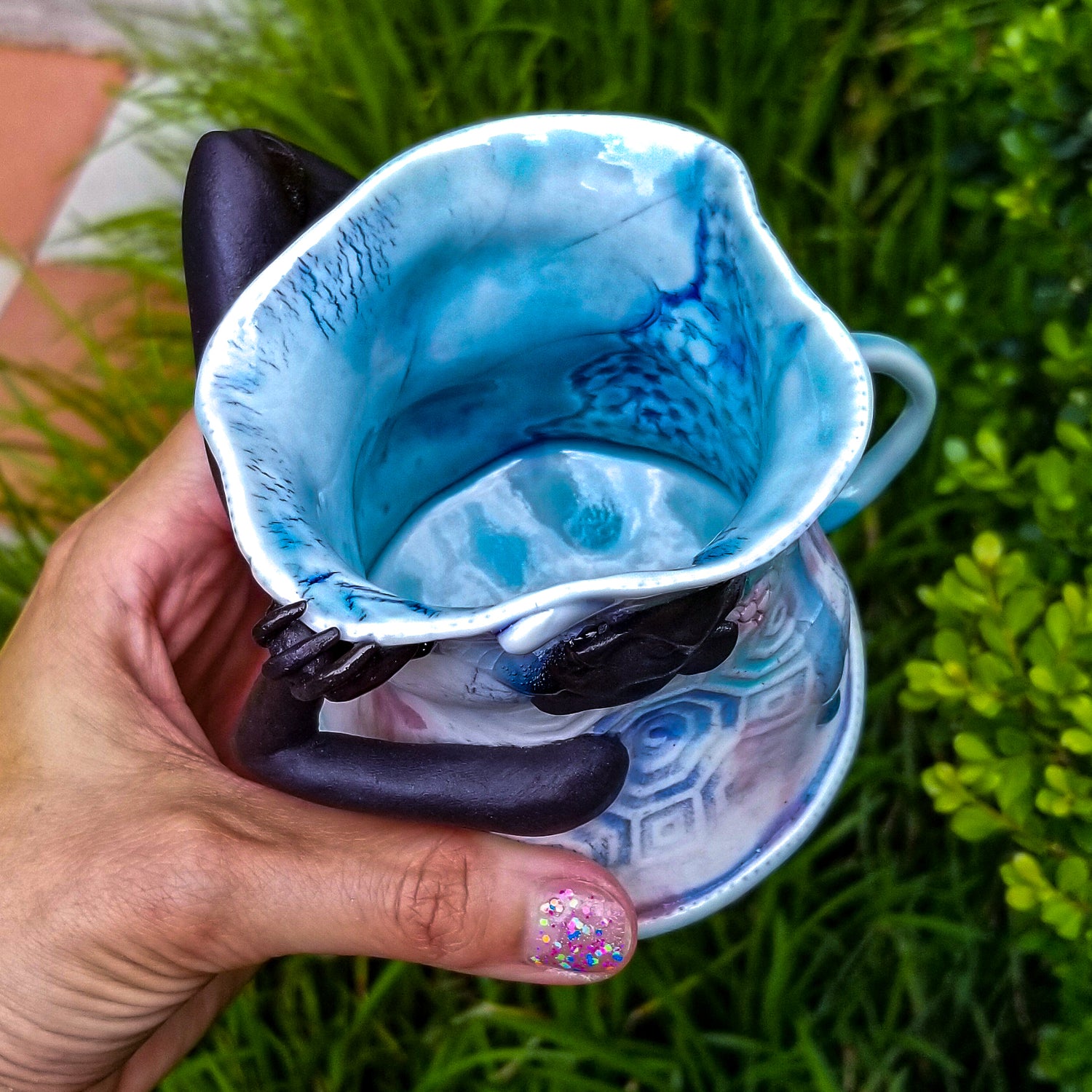 Inside detail of handmade porcelain mug with figurative sculptural elements