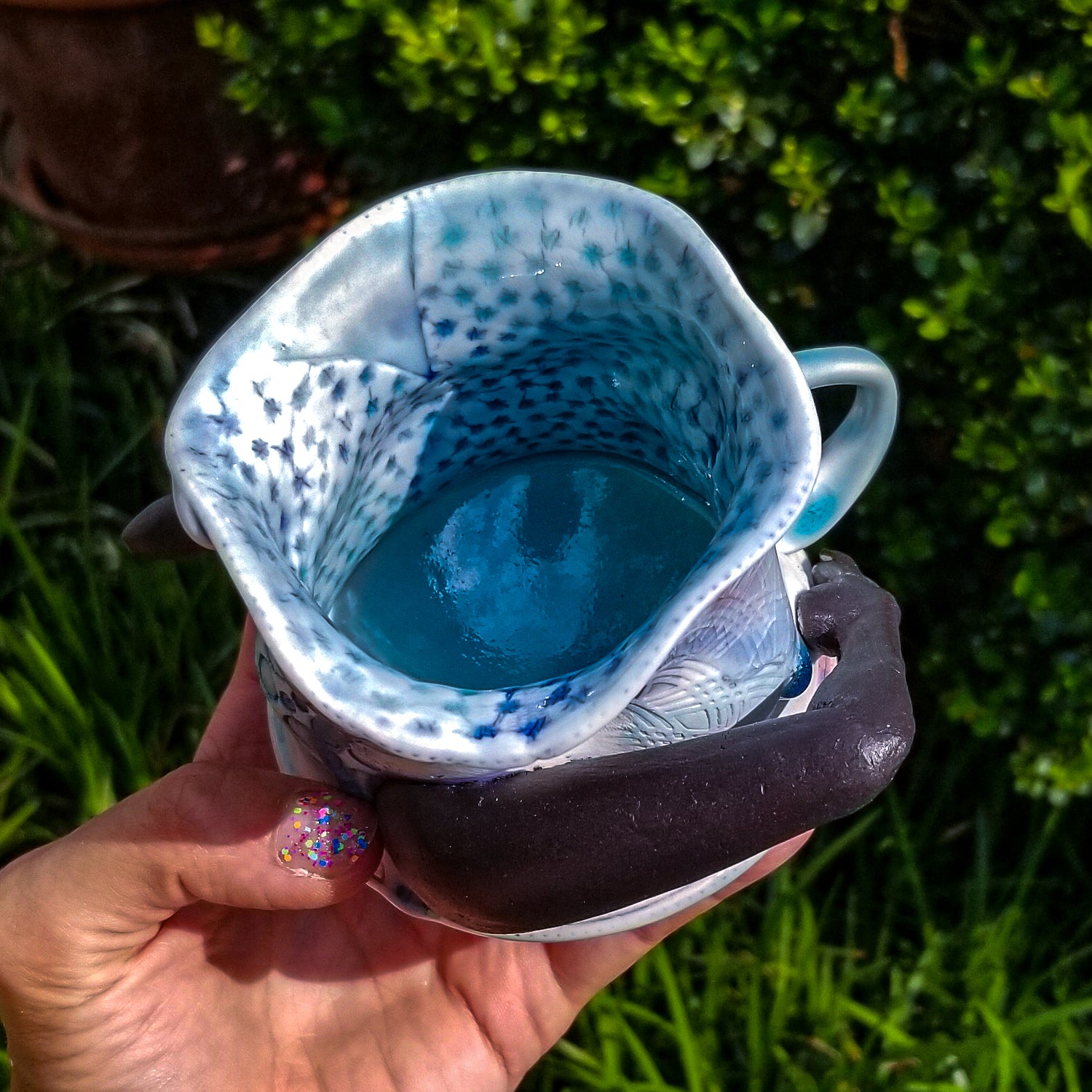 Inside detail of handmade porcelain mug with figurative sculptural elements