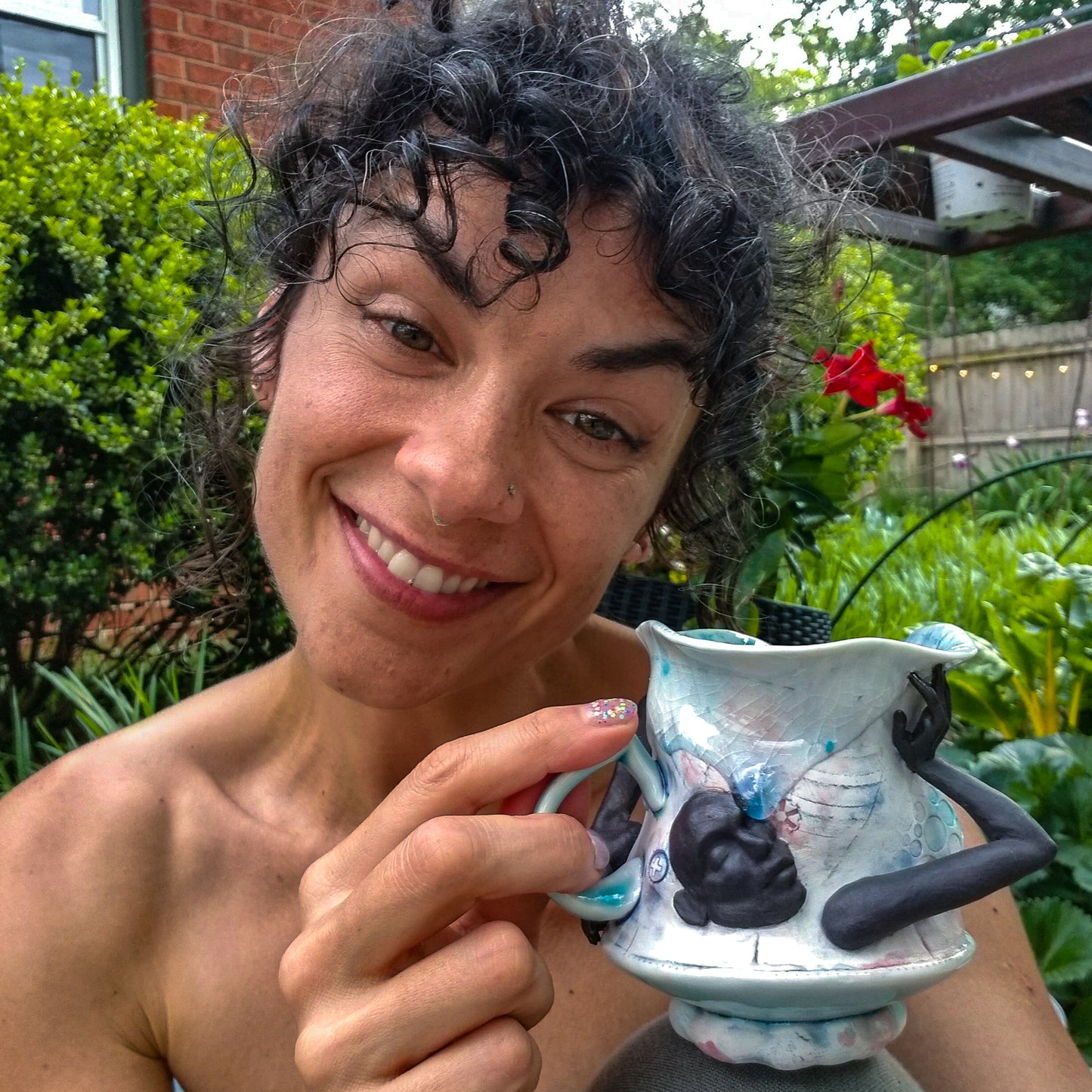 Artist C.A.Traen with handmade porcelain mug with figurative sculptural elements