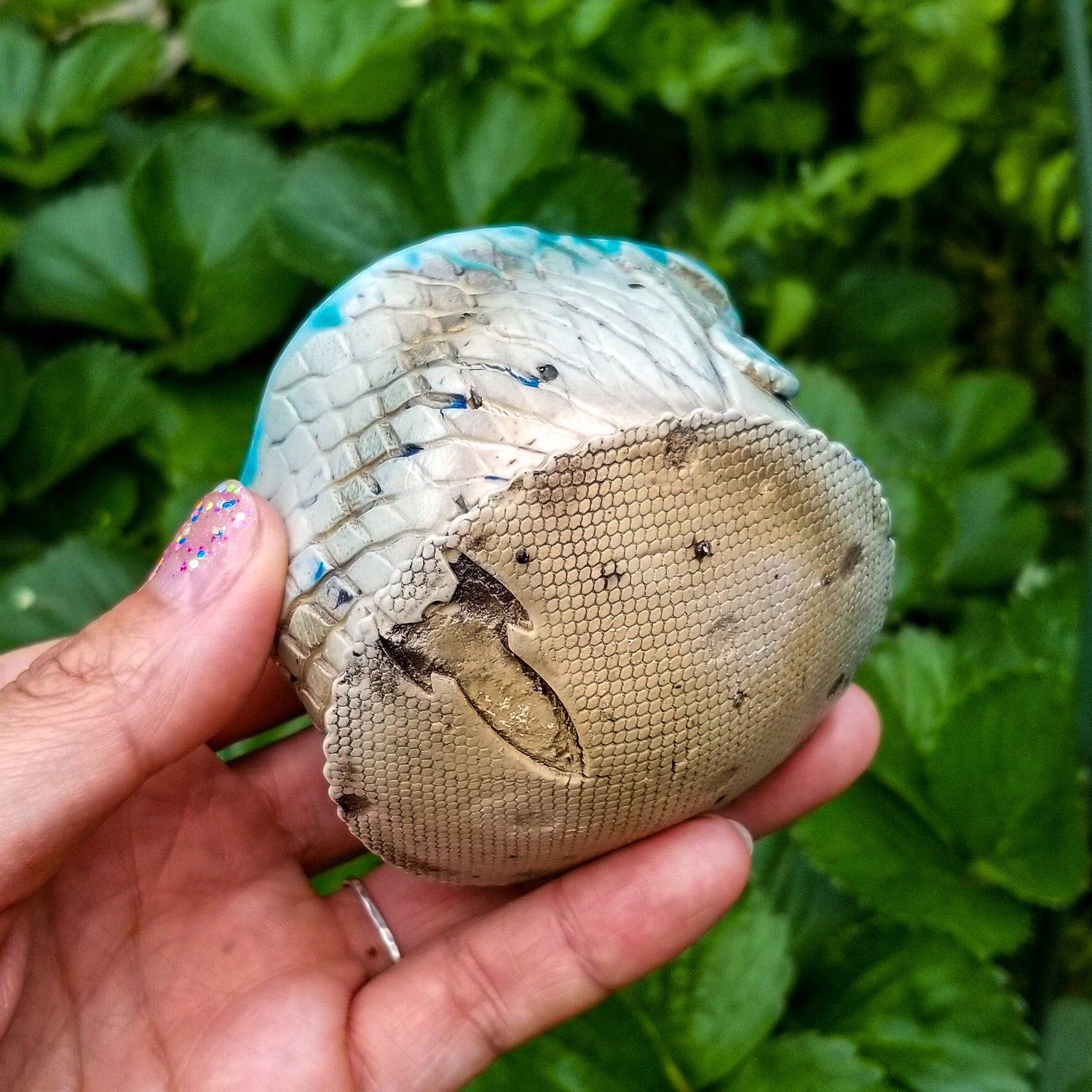 Bottom detail of handmade stoneware ceramic soda fired cup blue color with pressed textures