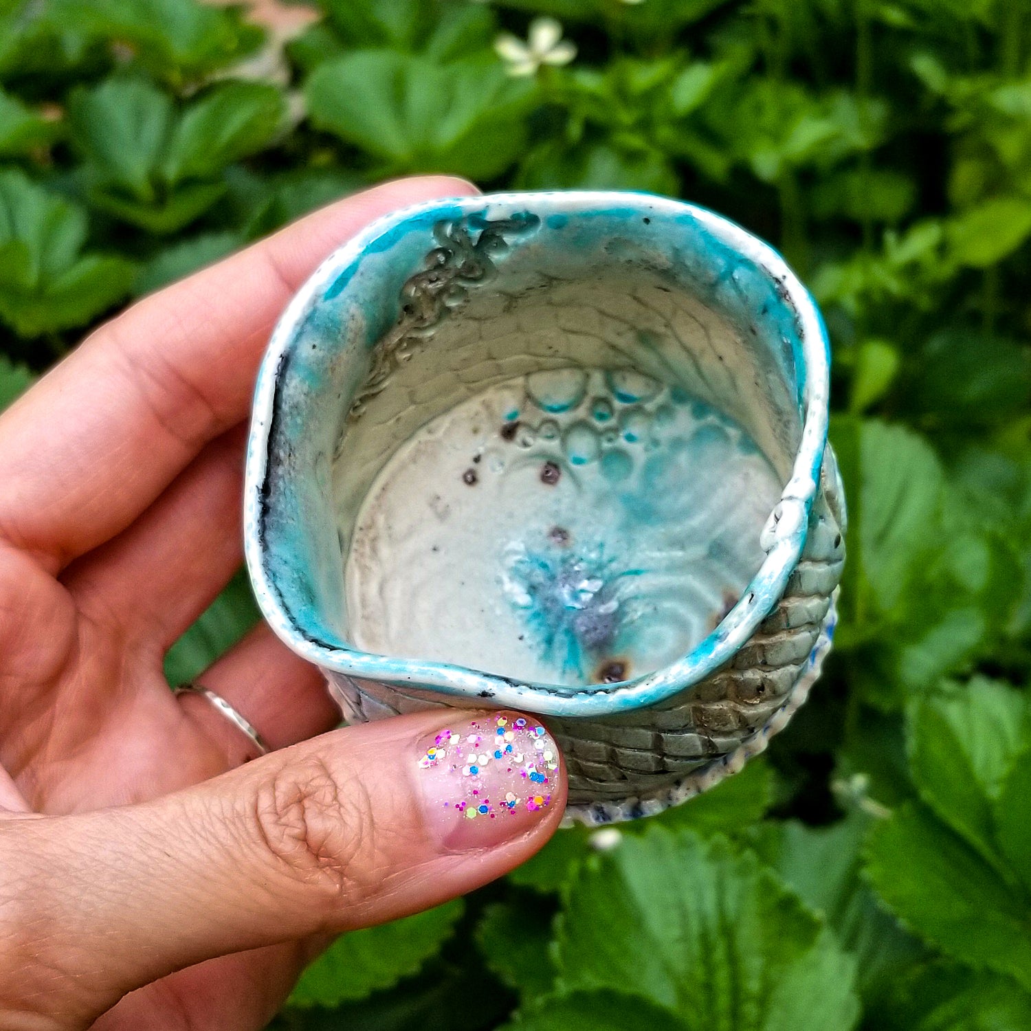 Inside detail of handmade stoneware ceramic soda fired cup blue color with pressed textures