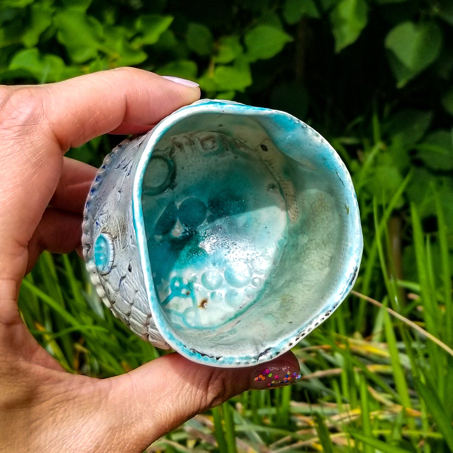 Inside detail of handmade stoneware ceramic soda fired cup blue color with pressed textures