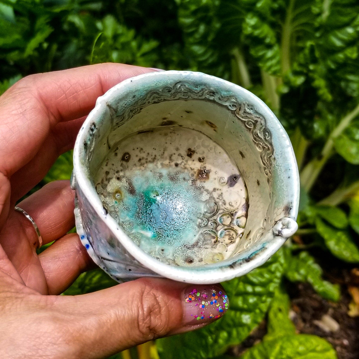 Inside detail of handmade stoneware ceramic soda fired cup blue color with pressed textures