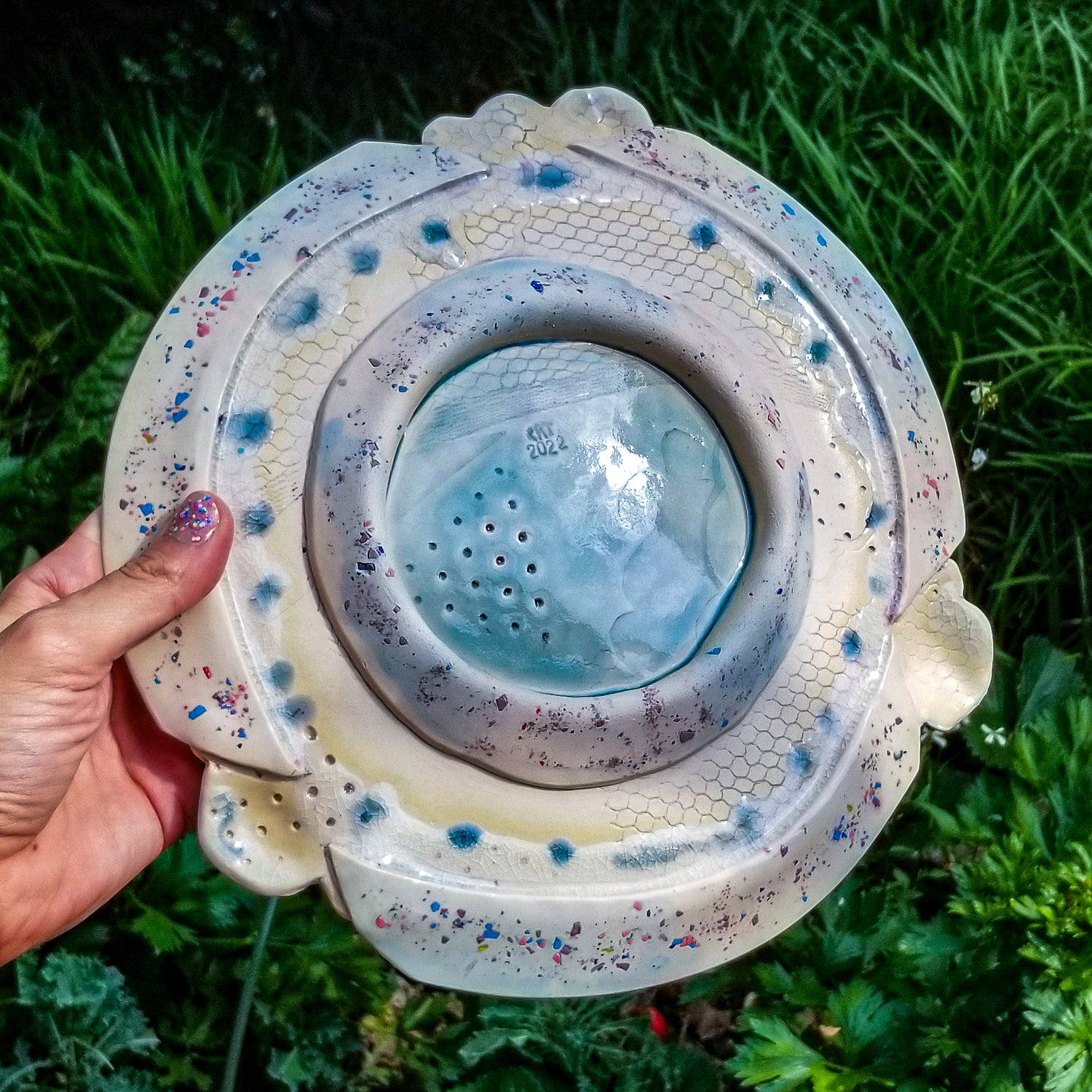 Bottom detail of handmade ceramic soda fired platter multi color with pressed textures