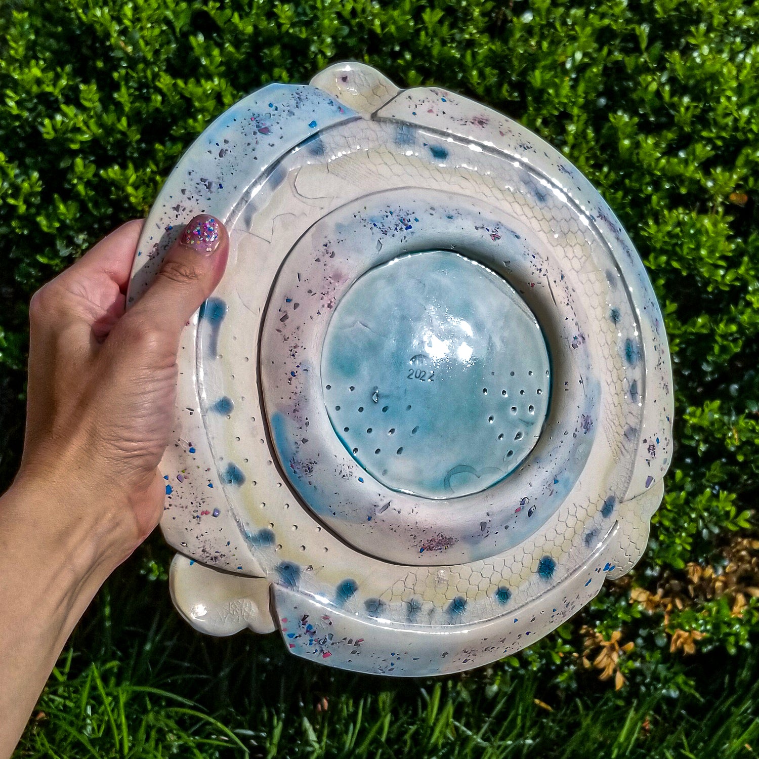 Bottom detail of handmade ceramic soda fired platter multi color with pressed textures
