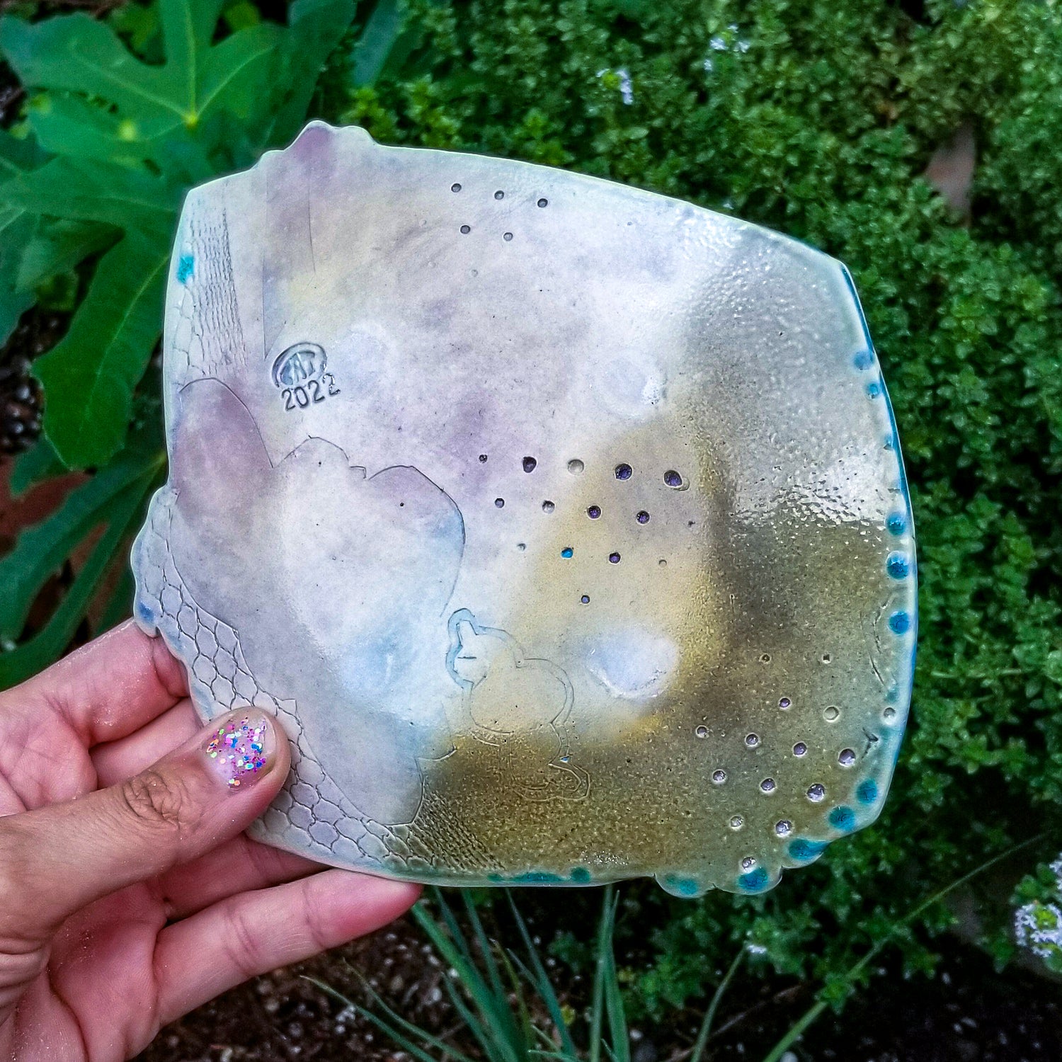 Bottom detail of handmade porcelain ceramic soda fired dish multi color with pressed textures