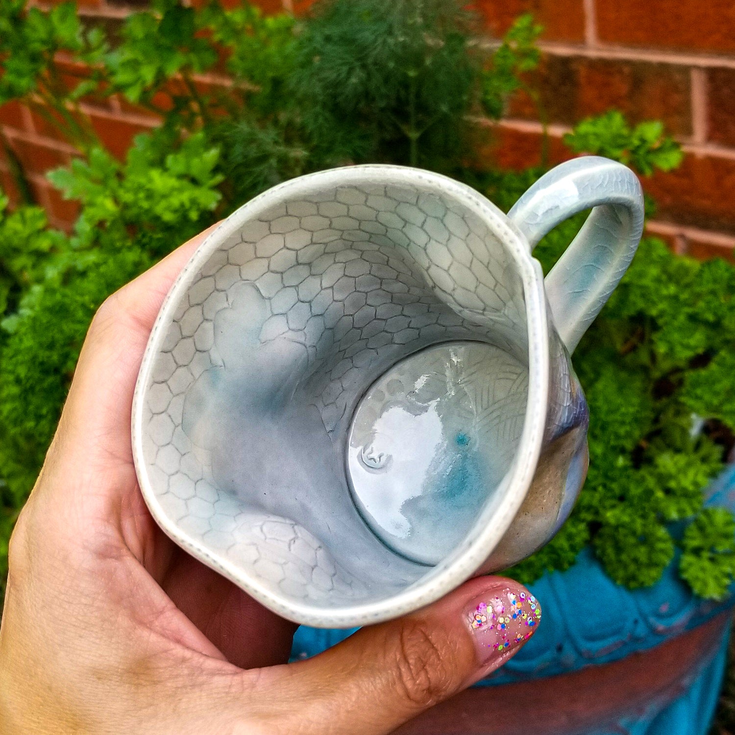 Inside detail of handmade stoneware ceramic soda fired mug blue color with pressed textures