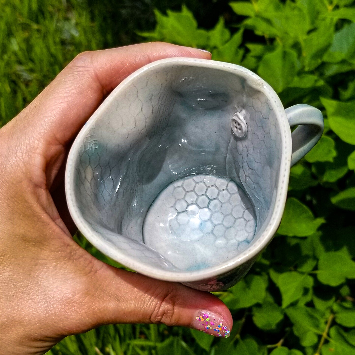 Inside detail of hndmade stoneware ceramic soda fired mug blue color with pressed textures
