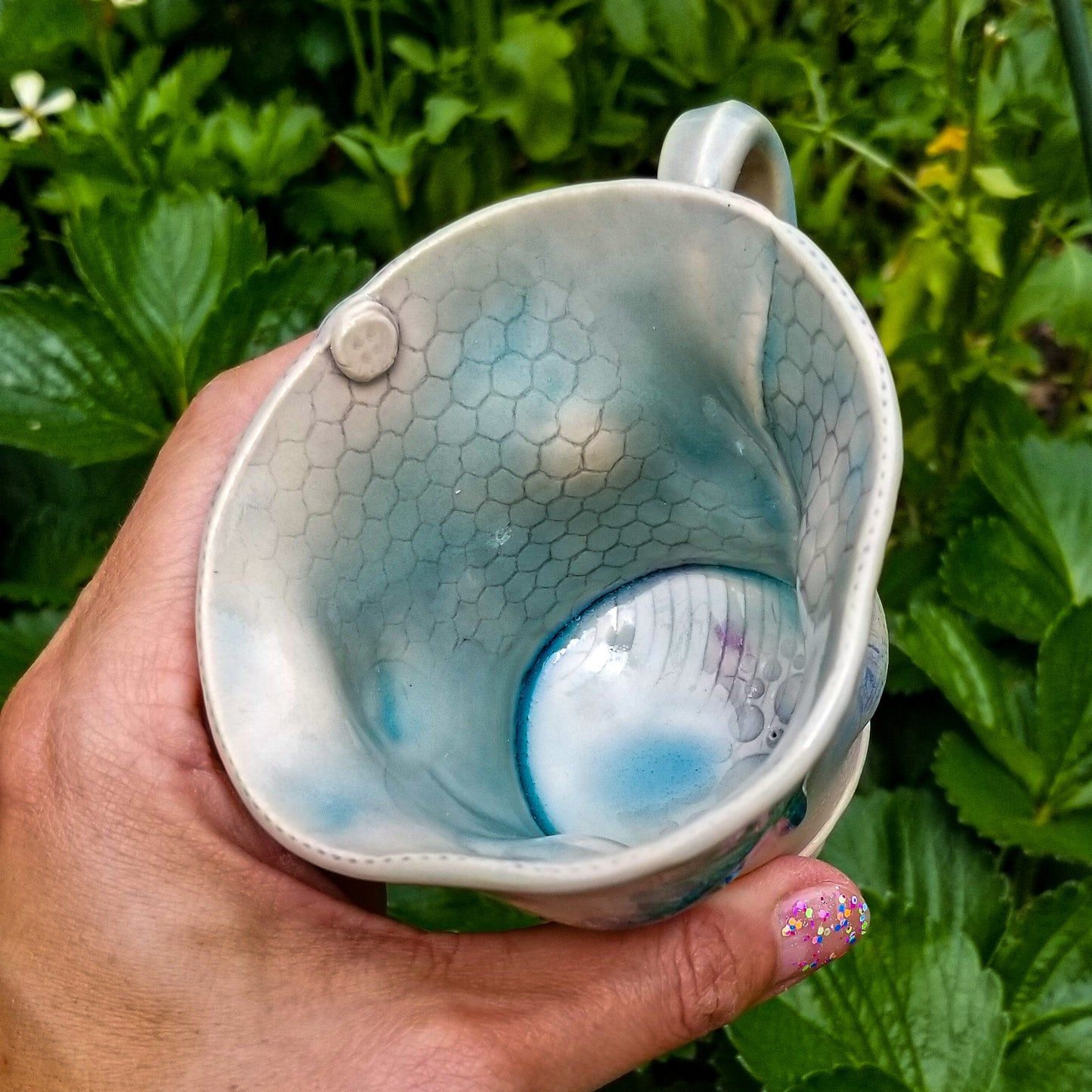Inside detail of handmade stoneware ceramic mug blue color with pressed textures