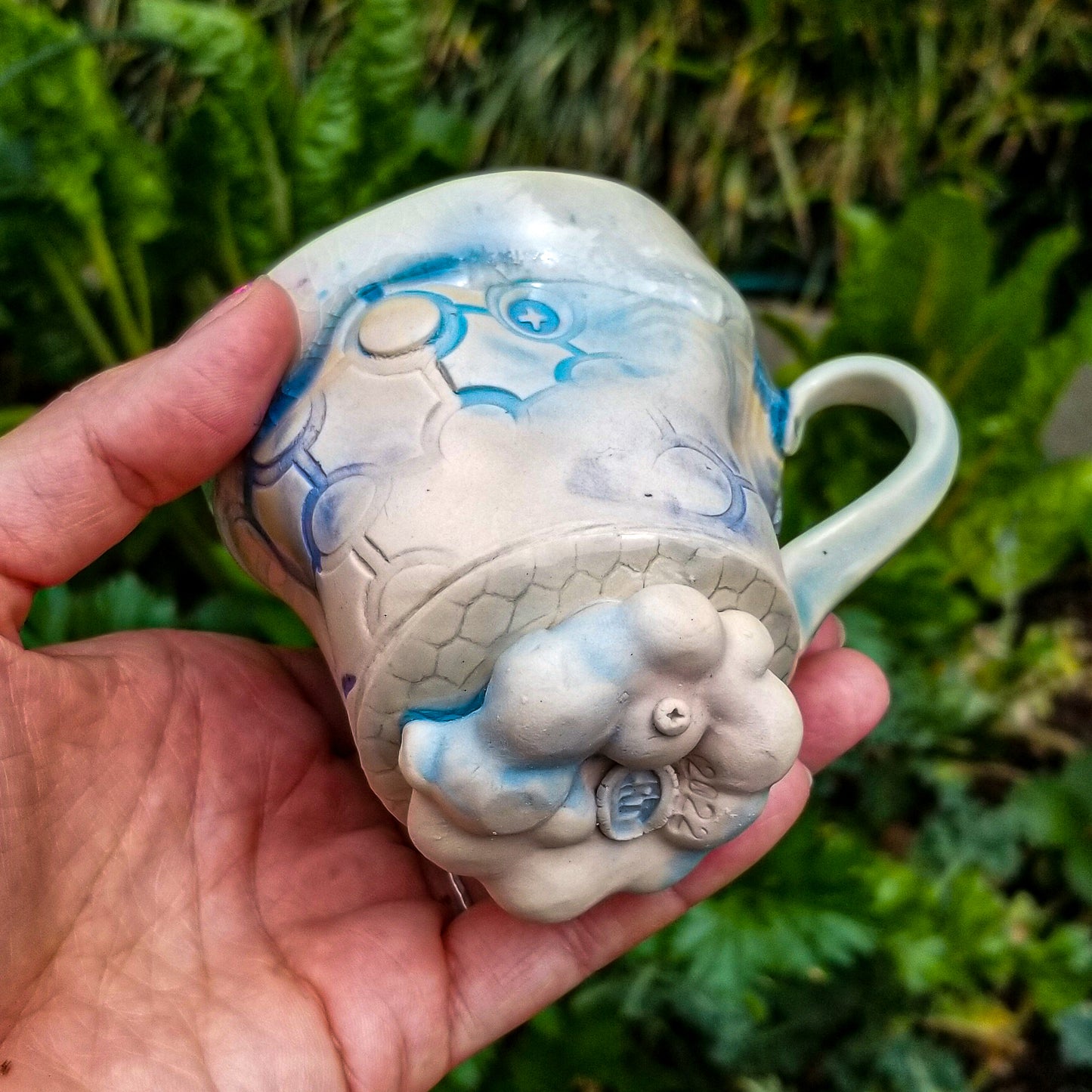 Bottom detail of handmade stoneware ceramic mug blue color with pressed textures