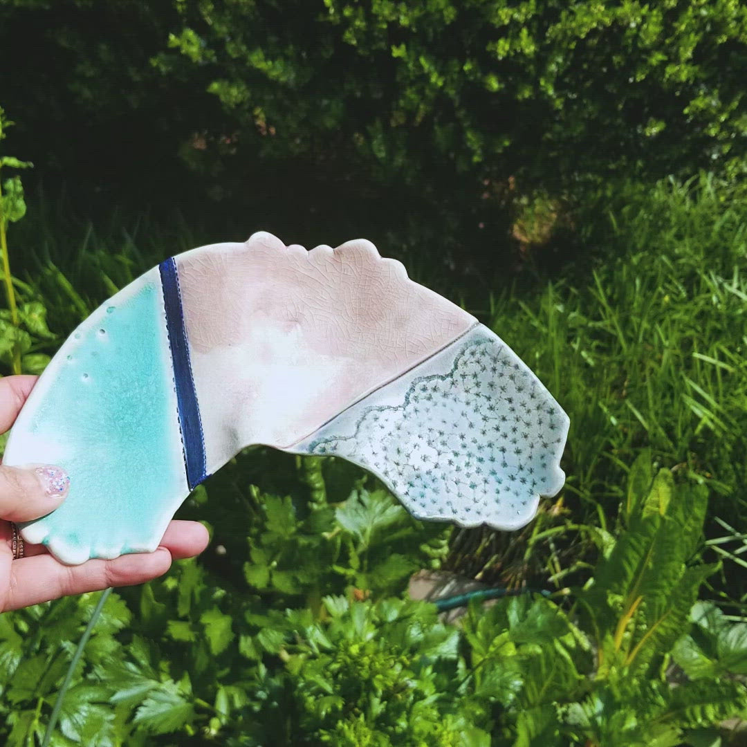 Video of handmade porcelain ceramic soda fired rainbow shaped tray multi color with pressed textures