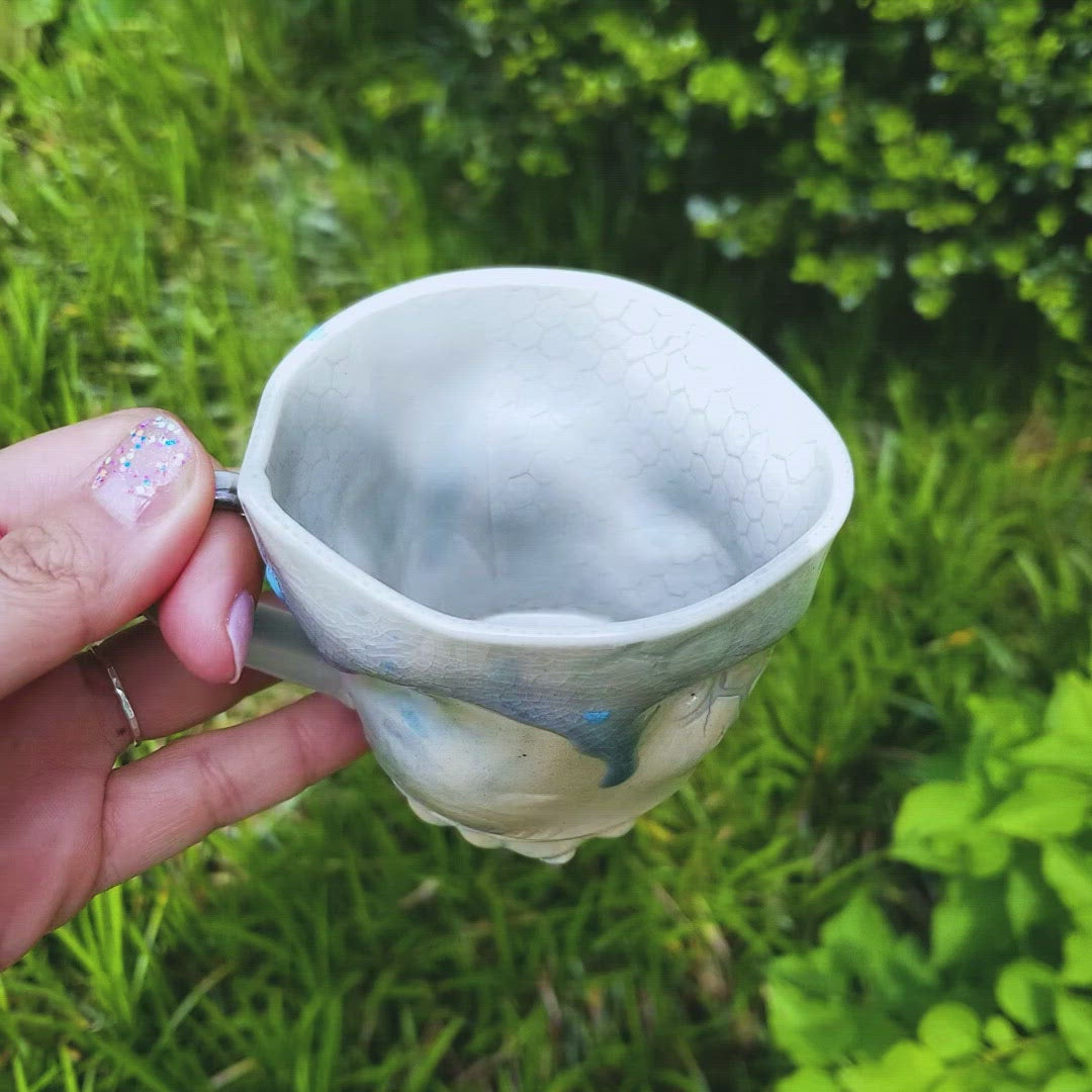 Video of handmade stoneware ceramic soda fired mug blue color with pressed textures